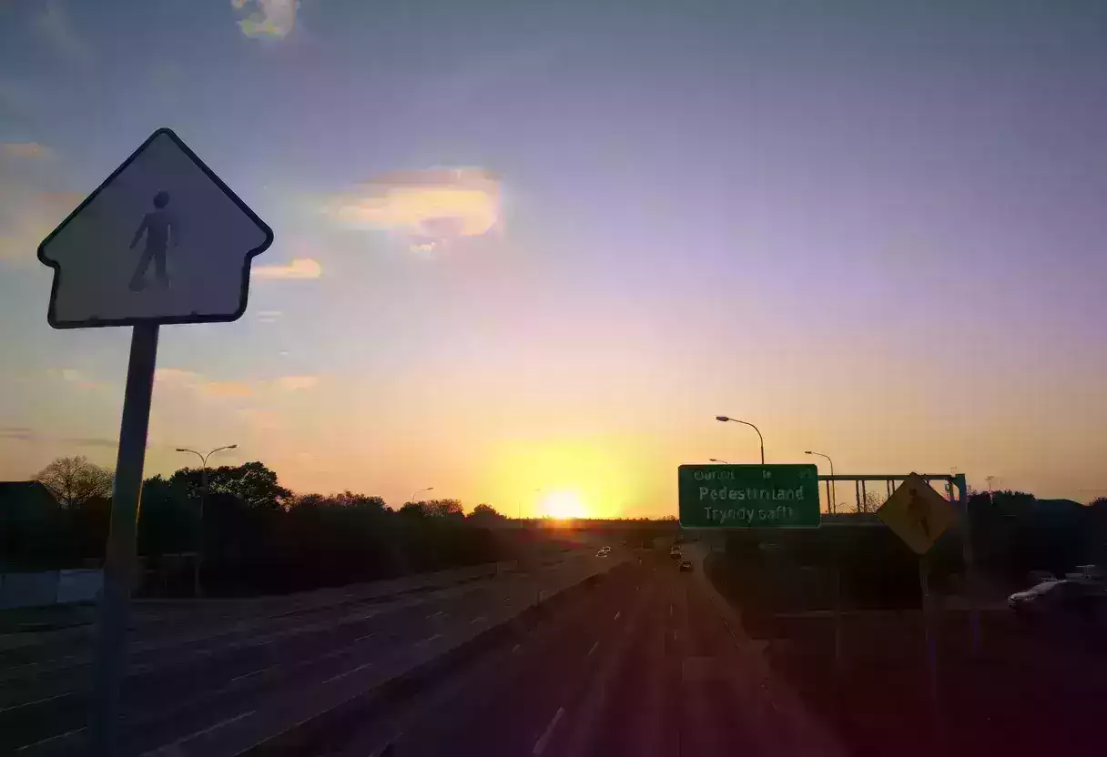 Traffic safety signs on a highway at sunset