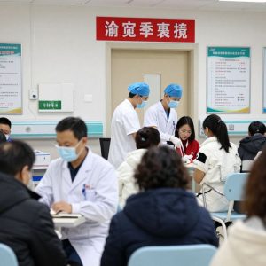 Medical staff attending to flu patients in a busy hospital setting