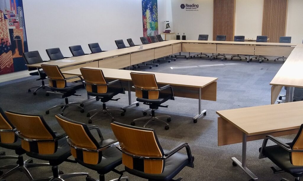 Empty council chamber with long tables