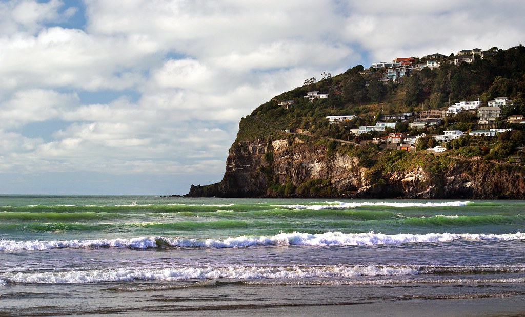 Empty sandy beach with ocean waves under a blue sky
