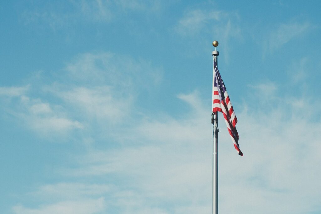 American flag flying on a pole against a blue sky