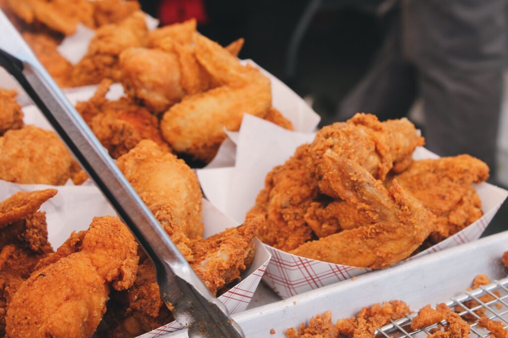 Southern fried chicken pieces in paper boats, the centerpiece of a Sunday lunch plate